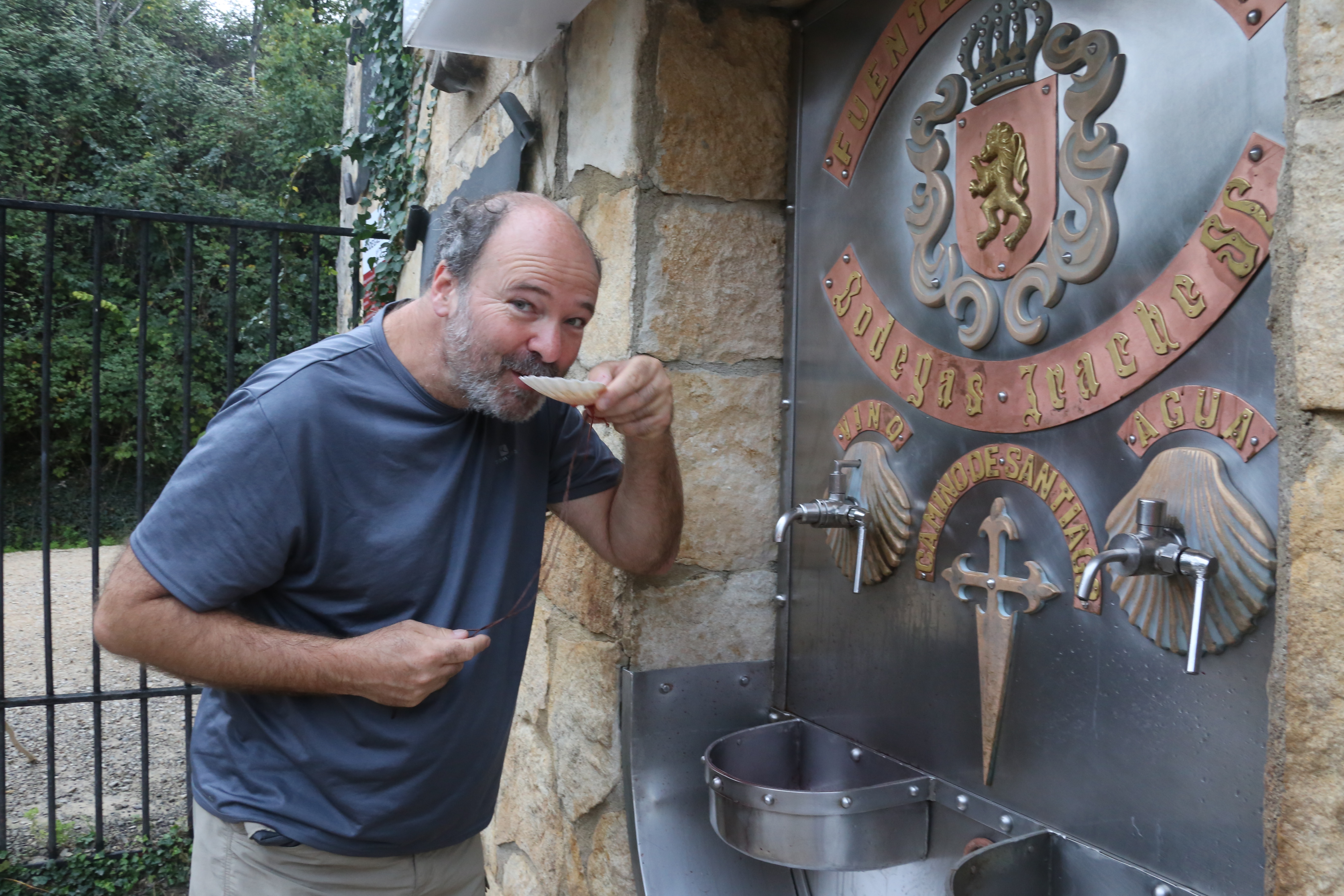 Ein Mann trinkt aus einem Wasserbrunnen